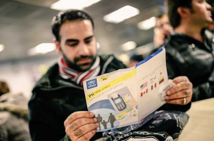 شاب سوري يقرأ تعليمات حول اسستخدام بطاقة ptt