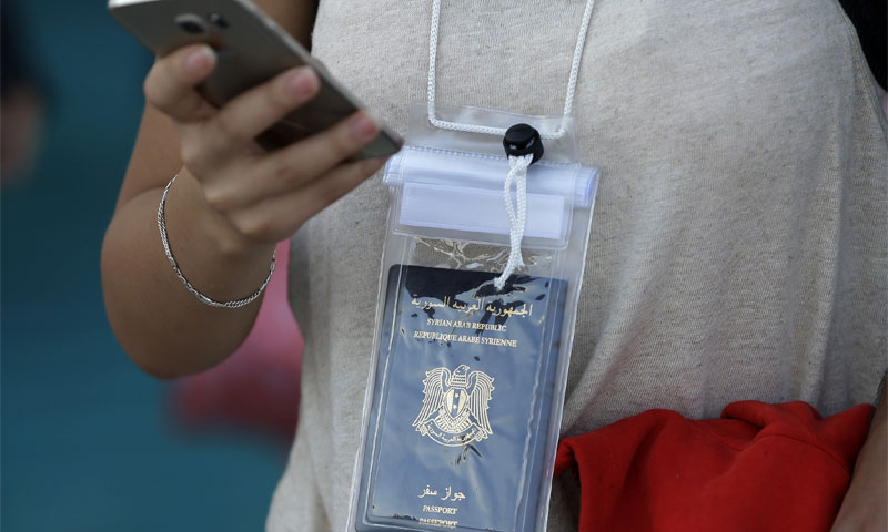 امرأة تحمل جواز سفر سوري