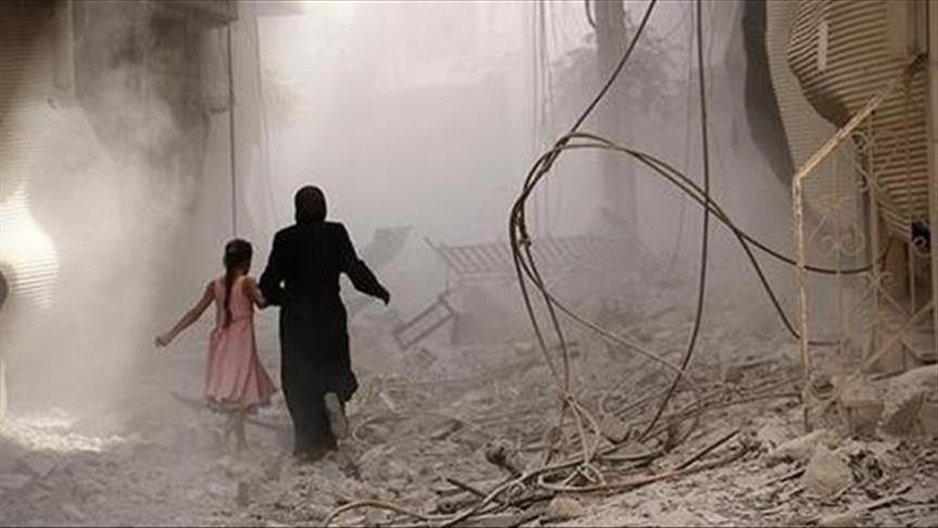 امرأة سورية تهرب أثناء القصف