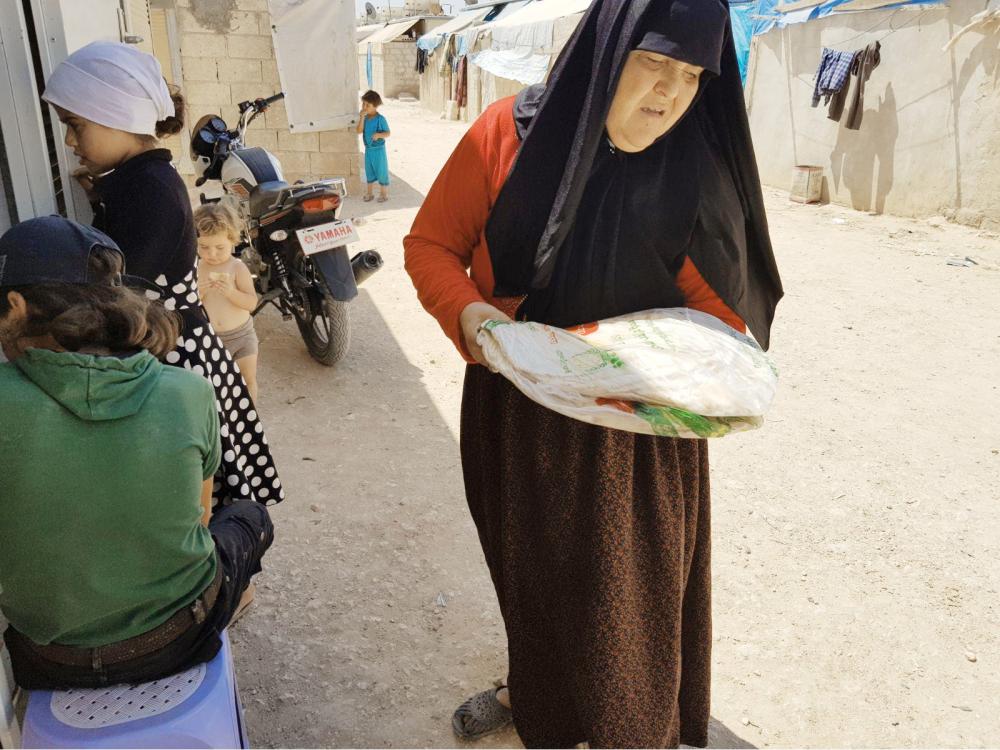 امرأة سورية تشتري الخبز