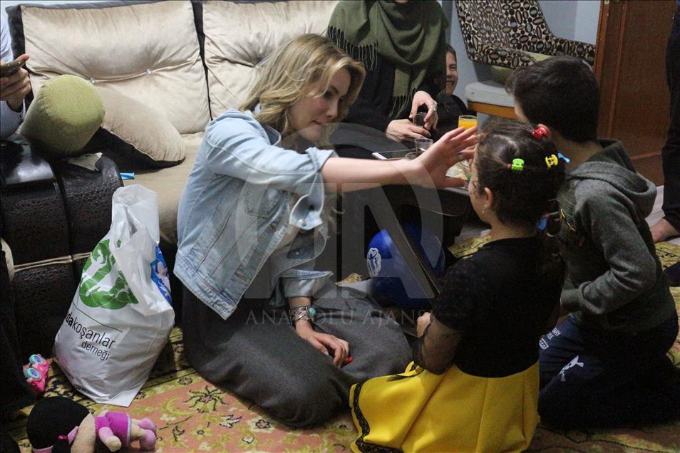 شاهد بالصور.. ممثلة تركية تشارك عائلة سورية إفطارها في إسطنبول
