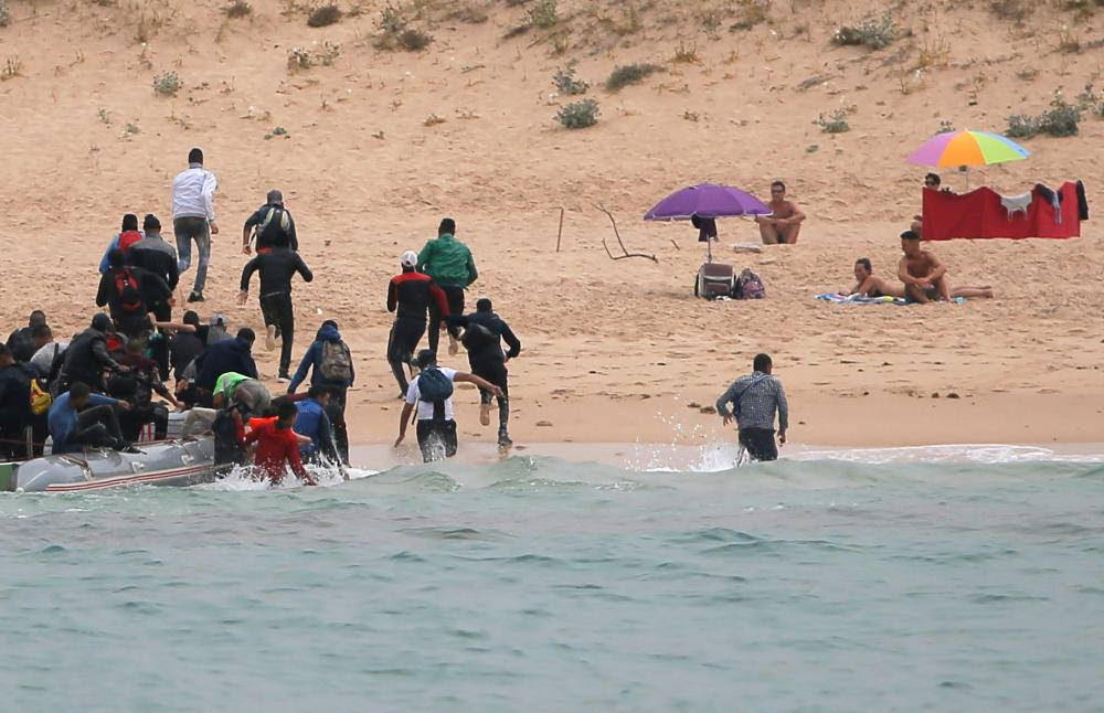 بالفيديو.. بلم لاجئين يصل إلى أحد شواطئ العراة في إسبانيا