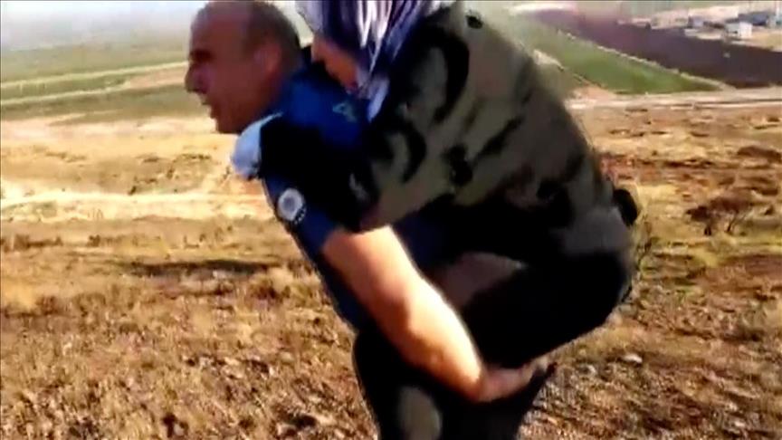 شرطي تركي يحمل على ظهره مصابة سورية مسافة 2 كيلومتر