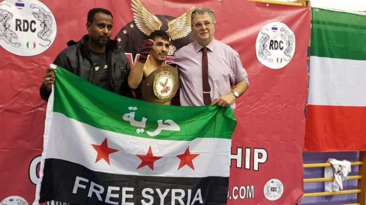 شاب سوري يحرز بطولة العالم برياضة "الكيك بوكسينغ" ويرفع علم الثورة السورية خلال تتويجه