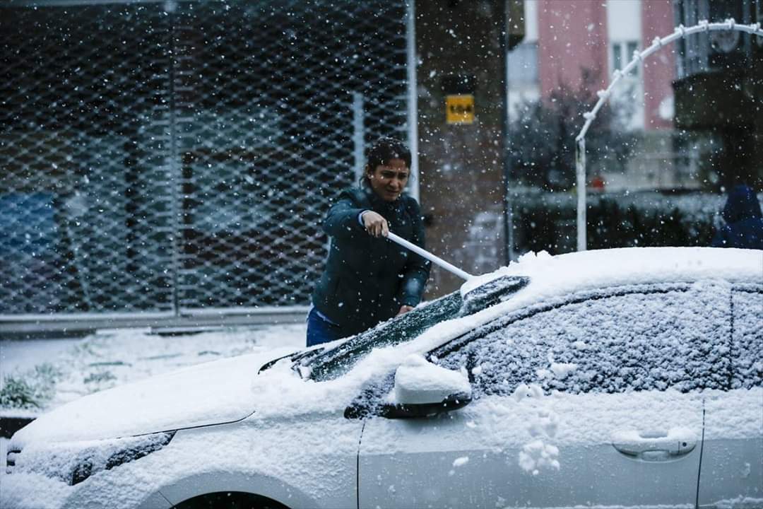 مواطن تركي يزيل الثلج عن سيارته