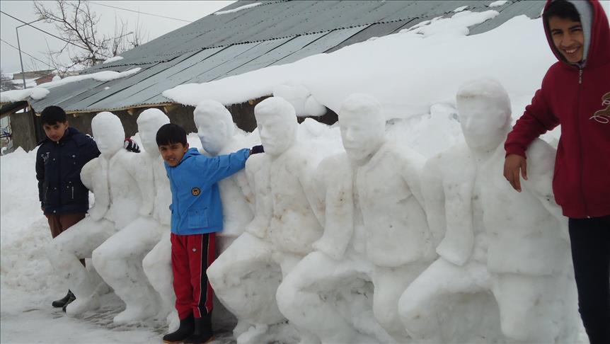 نحات تركي يشكل فريقا فولكلوريا من الثلج