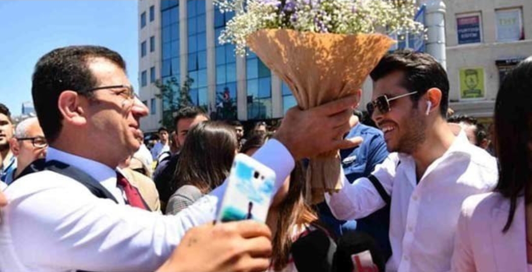 شاب سوري يهدي باقة زهور لأكرم إمام أوغلو .. وهكذا فسر فعلته بعد تعرضه لانتقادات