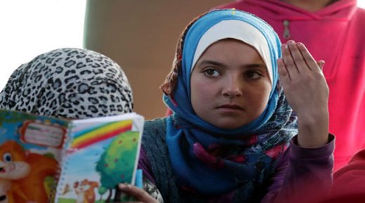 طفلة سورية تحصل على دروسها
