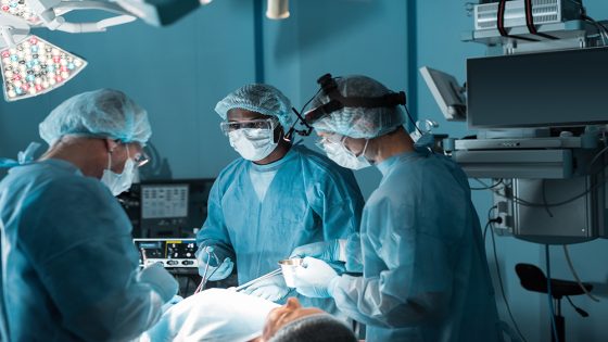 multicultural surgeons operating patient in operating room